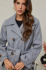 310 - Manteau long, col chemise, fermeture à six boutons avec un détaille boutons sur les poignets, une ceinture à la taille et deux poches à l'avant