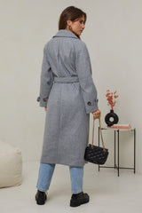 310 - Manteau long, col chemise, fermeture à six boutons avec un détaille boutons sur les poignets, une ceinture à la taille et deux poches à l'avant